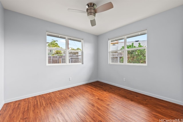 unfurnished room with ceiling fan, baseboards, and wood finished floors