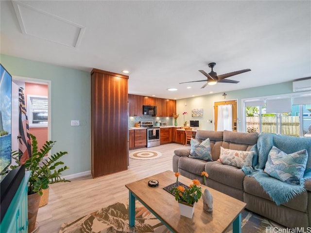 living area with recessed lighting, baseboards, light wood-type flooring, a wall mounted air conditioner, and attic access