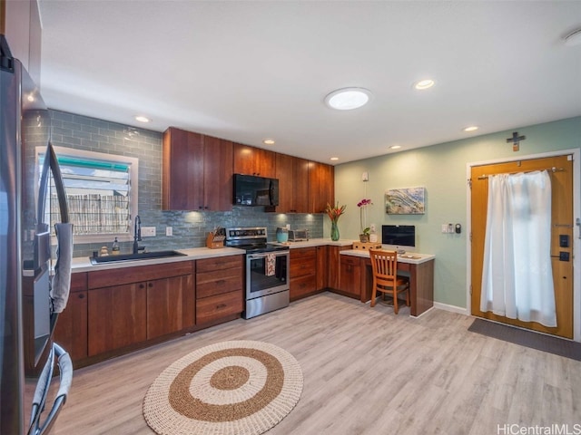 kitchen with tasteful backsplash, light wood-style flooring, stainless steel appliances, light countertops, and a sink