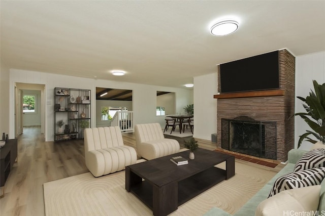 living room featuring a brick fireplace and wood finished floors