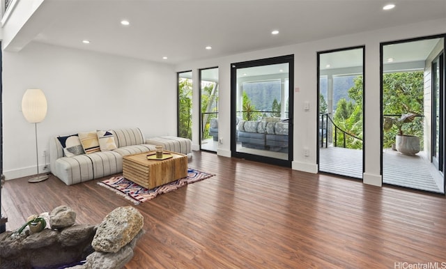 living area with plenty of natural light, dark wood-type flooring, and recessed lighting