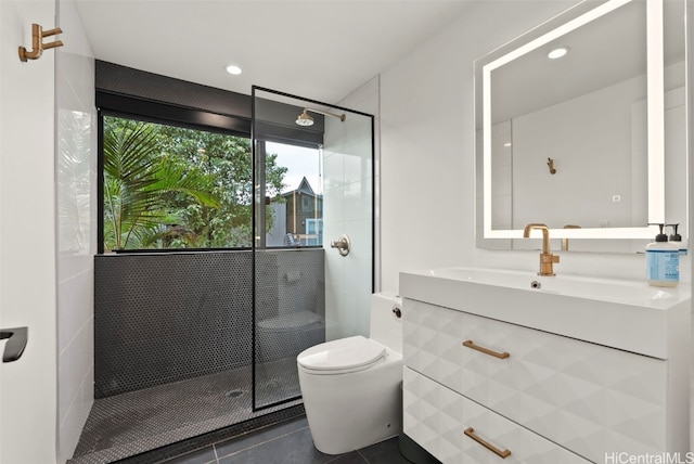 bathroom featuring toilet, a shower stall, vanity, and tile patterned floors