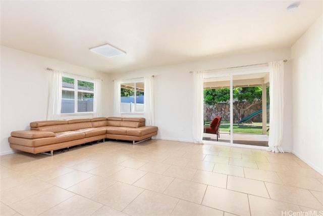 unfurnished living room featuring baseboards and a wealth of natural light