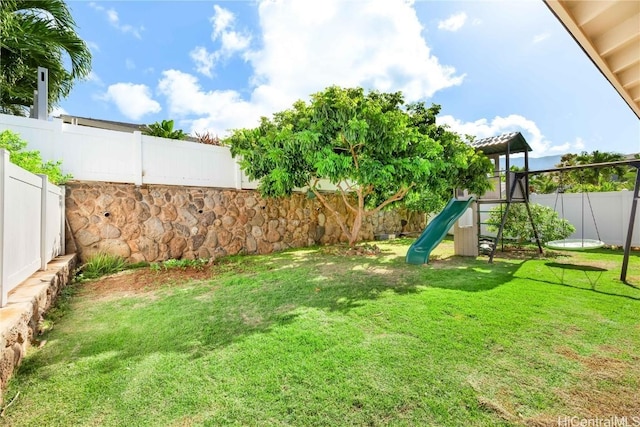 view of yard featuring a playground and a fenced backyard