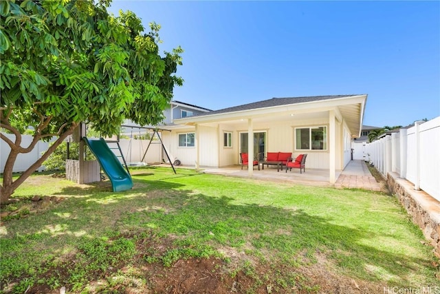 back of property with a patio area, a fenced backyard, a lawn, and a playground