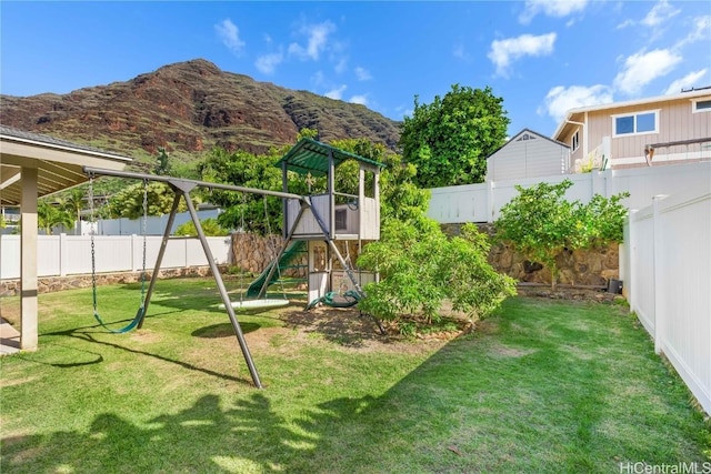 view of play area with a yard, a fenced backyard, and a mountain view