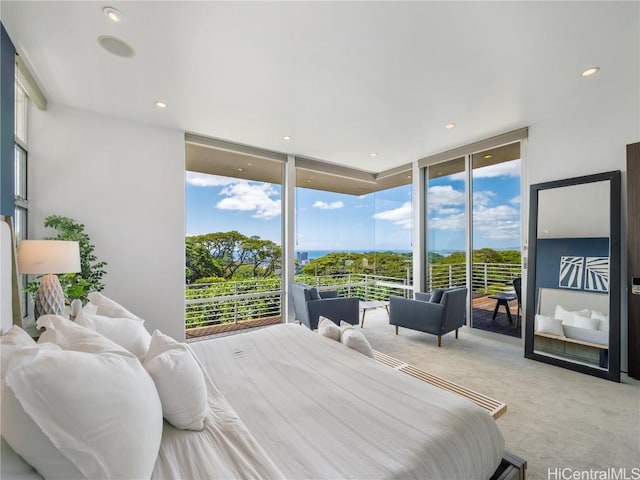 bedroom featuring multiple windows, a wall of windows, light colored carpet, and access to exterior