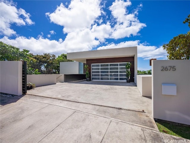 exterior space featuring a gate, a detached garage, and stucco siding