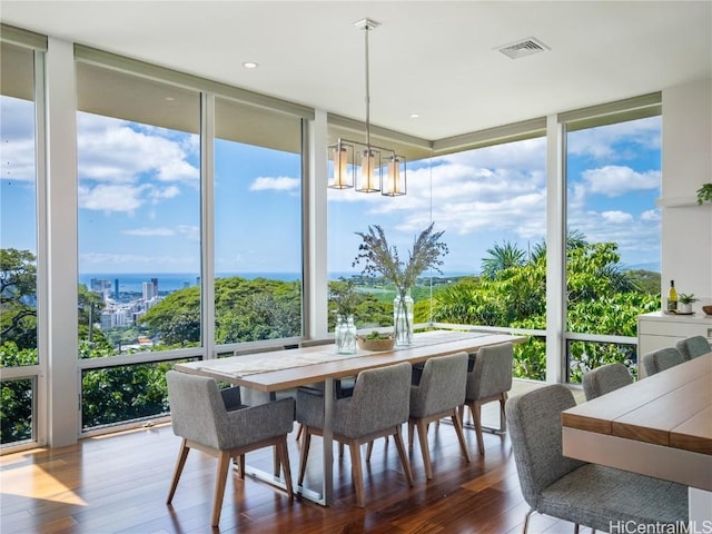 sunroom featuring a chandelier, a water view, and visible vents