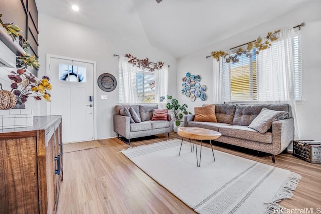 living room featuring light wood-type flooring and vaulted ceiling