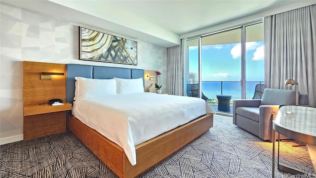 bedroom with access to exterior, expansive windows, and a water view