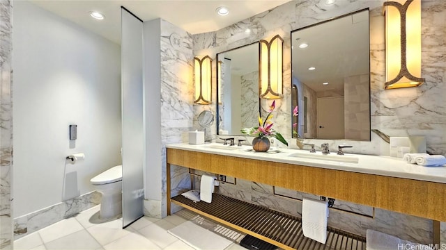 bathroom featuring a sink, tile walls, toilet, and stone wall