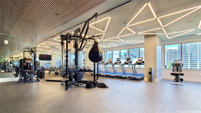 exercise room featuring a city view and baseboards