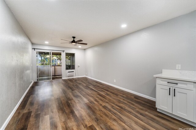 unfurnished room featuring recessed lighting, a wall mounted AC, baseboards, a ceiling fan, and dark wood-type flooring