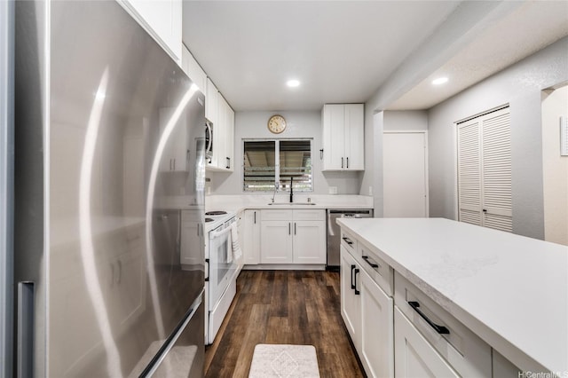 kitchen featuring white cabinetry, a sink, appliances with stainless steel finishes, light countertops, and recessed lighting
