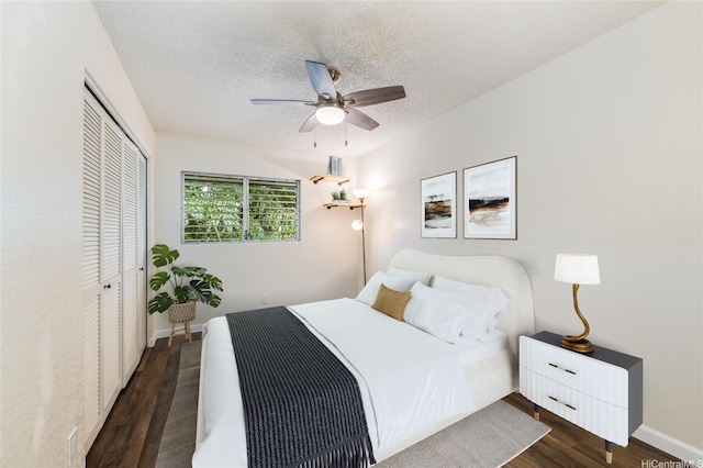 bedroom with a closet, ceiling fan, baseboards, a textured ceiling, and dark wood-type flooring