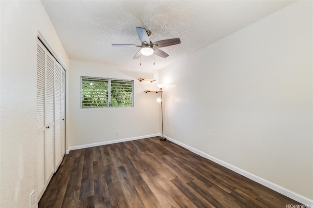 unfurnished bedroom featuring wood finished floors, a closet, ceiling fan, baseboards, and a textured ceiling