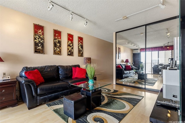 living area with track lighting, a textured ceiling, and wood finished floors