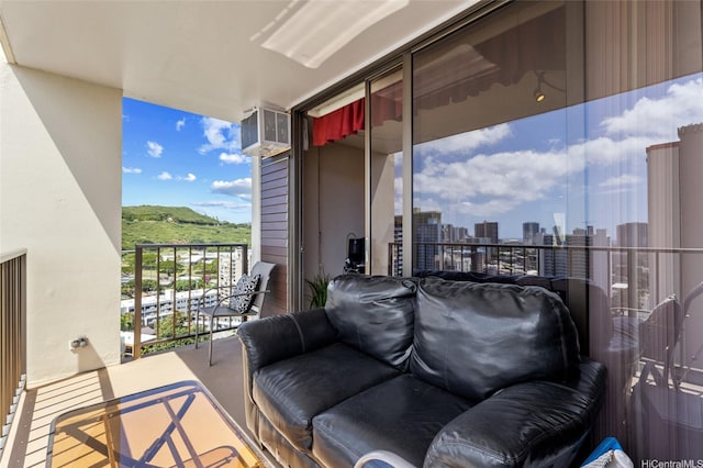 balcony featuring a city view and a wall mounted air conditioner