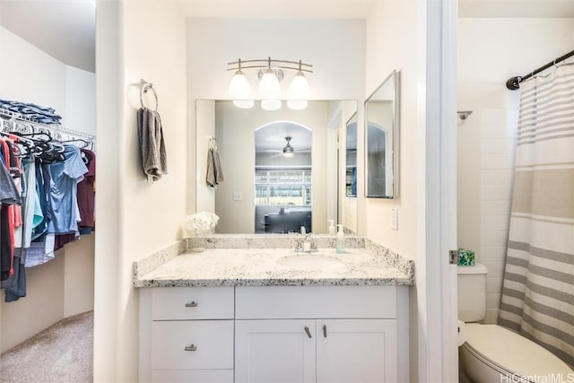 ensuite bathroom featuring toilet, ensuite bathroom, curtained shower, vanity, and a spacious closet