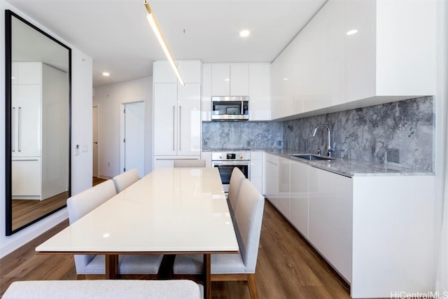 kitchen featuring white cabinets, modern cabinets, stainless steel appliances, and light countertops