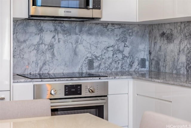 kitchen with stainless steel appliances, white cabinets, backsplash, and modern cabinets