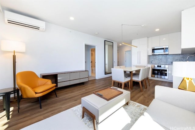 living room with dark wood-style flooring, a wall unit AC, and recessed lighting