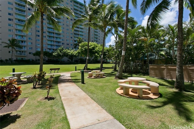 view of home's community with fence and a yard