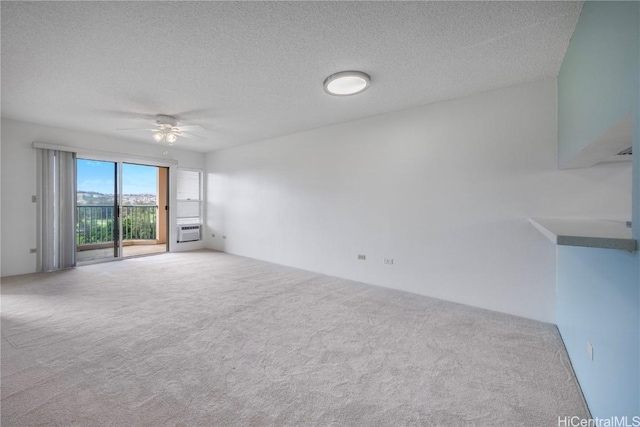 unfurnished living room with ceiling fan, a textured ceiling, a wall unit AC, and carpet flooring