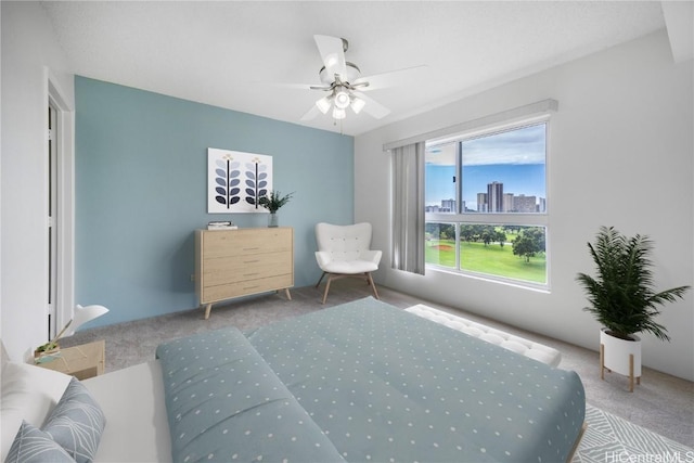 bedroom featuring carpet, a city view, and ceiling fan