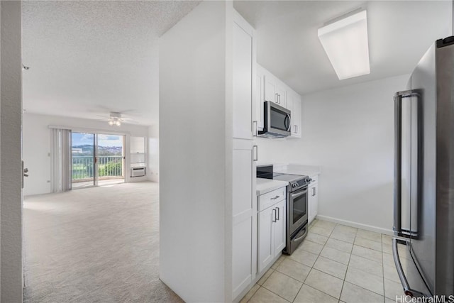 kitchen with stainless steel appliances, light countertops, white cabinets, and ceiling fan