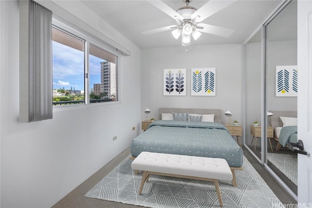 bedroom with a ceiling fan and a city view