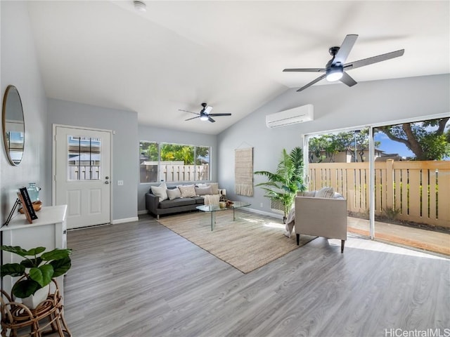 living room with light wood-style flooring, baseboards, vaulted ceiling, and a wall mounted air conditioner