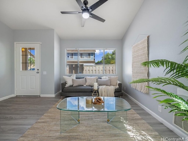 living room featuring ceiling fan, baseboards, a wealth of natural light, and wood finished floors