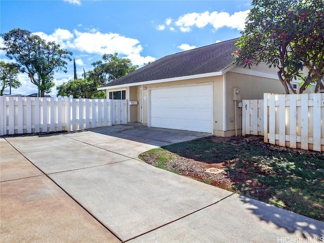 garage featuring driveway and fence