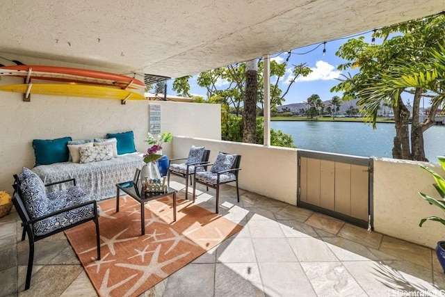 balcony featuring a water view and an outdoor living space