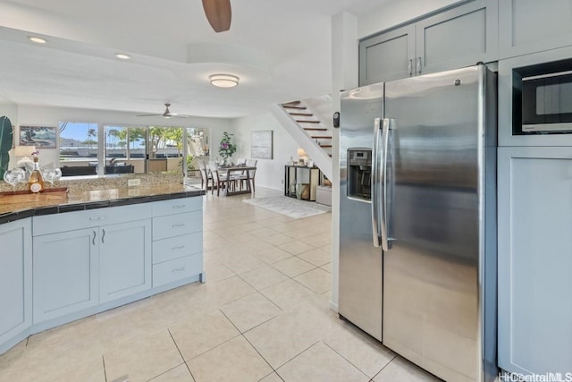 kitchen featuring stainless steel refrigerator with ice dispenser, light tile patterned floors, dark countertops, recessed lighting, and a ceiling fan