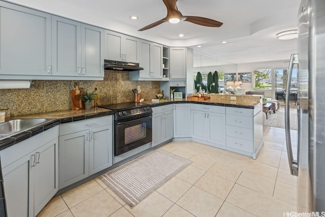 kitchen with light tile patterned floors, dark countertops, a peninsula, black range with electric cooktop, and under cabinet range hood