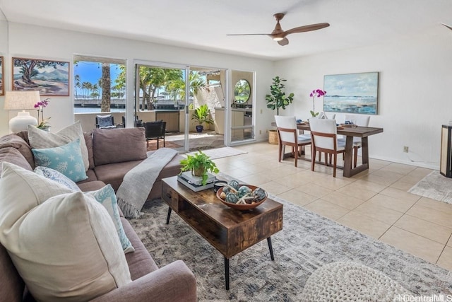 living room with a ceiling fan, baseboards, and light tile patterned floors