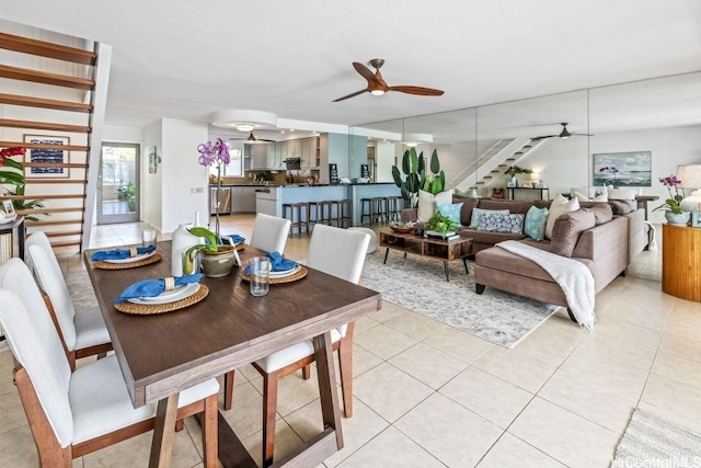 dining space featuring a ceiling fan, stairway, and light tile patterned floors