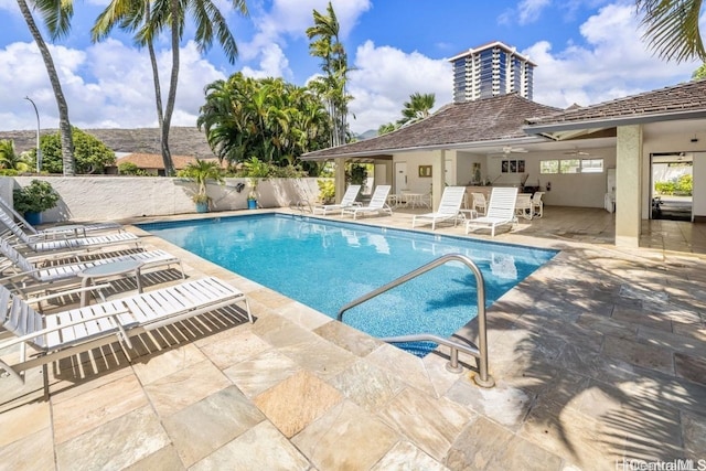 pool with a patio and fence