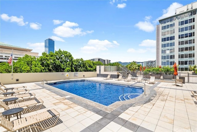 community pool featuring fence and a patio