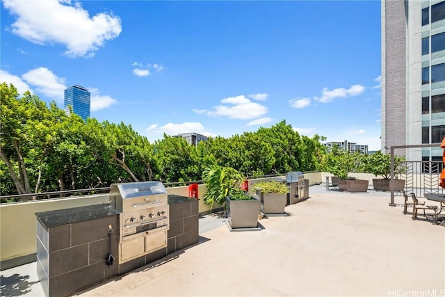 view of patio / terrace featuring grilling area, an outdoor kitchen, and a city view