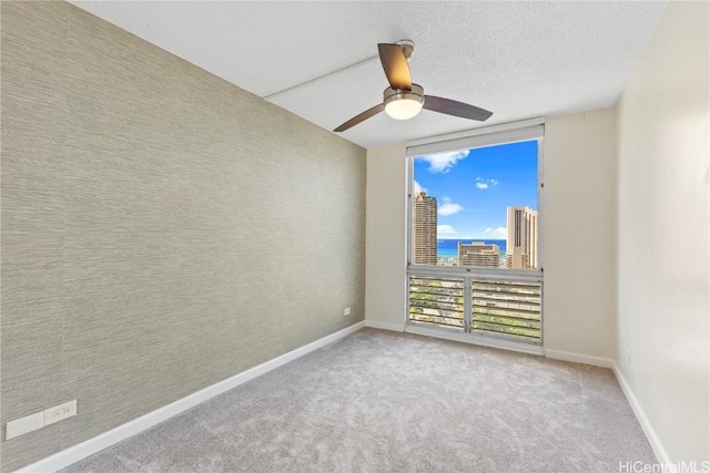 unfurnished room featuring expansive windows, carpet, a view of city, and baseboards