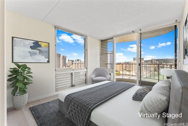 carpeted bedroom with access to exterior, a view of city, expansive windows, a textured ceiling, and baseboards