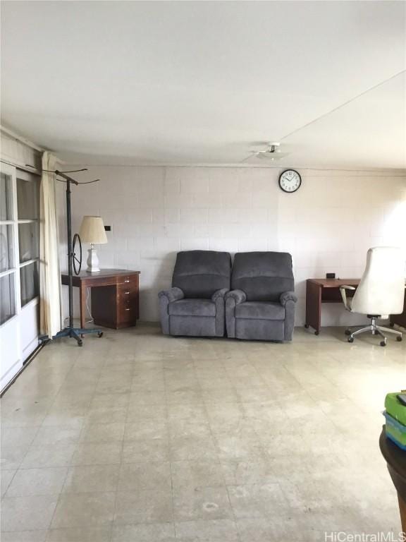 unfurnished living room featuring concrete block wall and light floors