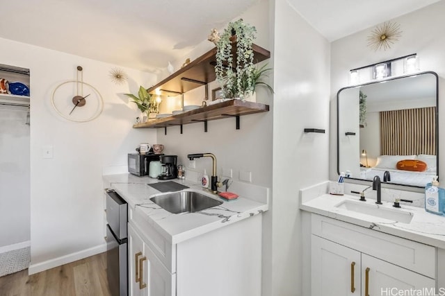 kitchen with white cabinets, a sink, and open shelves