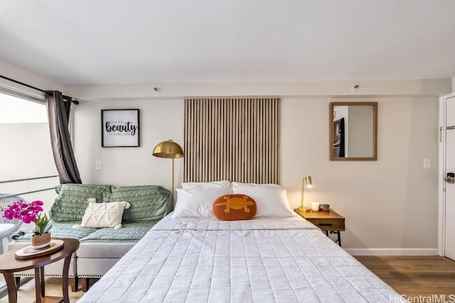 bedroom with wood finished floors and baseboards