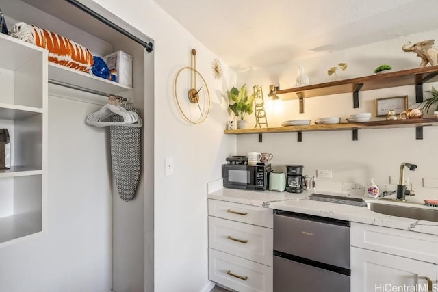 bar featuring black microwave, dishwasher, and a sink