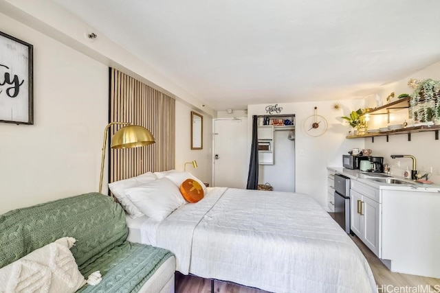 bedroom featuring light wood-style floors and a sink